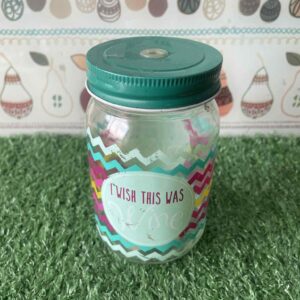 ขวดโหลแก้วที่มีฝาสีเขียวเข้มและมีลวดลายสีสันสดใสบนตัวขวด