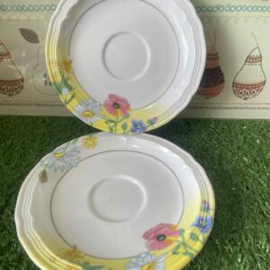 จานรองถ้วยกาแฟหรือชาที่มีลวดลายดอกไม้หลากสีสันบนพื้นสีขาวและสีเหลืองอ่อนขอบหยัก