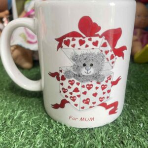 แก้วมัคใบนี้มีข้อความภาษาอังกฤษว่า “For MUM” ซึ่งแปลว่า “สำหรับแม่” และมีรูปตุ๊กตาหมีเท็ดดี้แบร์อยู่ในกล่องของขวัญที่ตกแต่งด้วยรูปหัวใจและริบบิ้นสีแดง