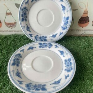 ถาดรองถ้วยเซรามิกสีขาวลายดอกไม้และเถาวัลย์สีน้ำเงินนี้อาจเป็นส่วนหนึ่งของชุด